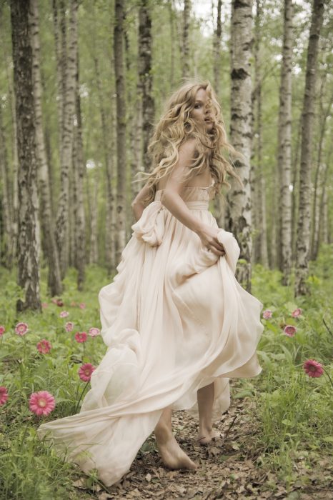 Chica corriendo por un campo de flores 