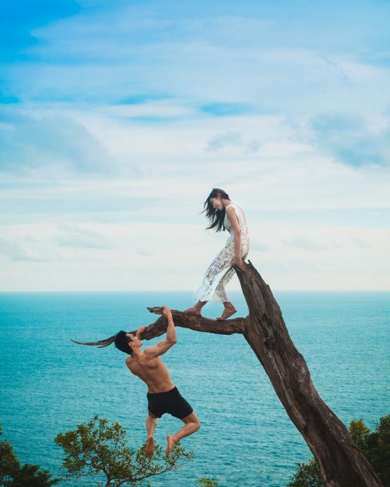 pareja en un tronco frente al mar