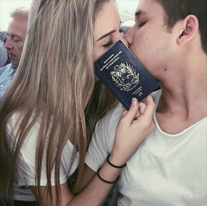 mujer le da un beso a su novio con pasaporte en la mano 