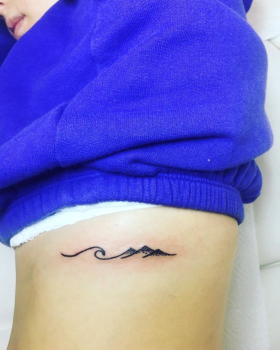 Tatuaje costillas ola y montaña
