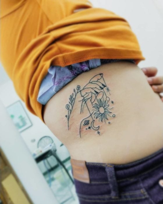 tatuaje costillas mano con flores