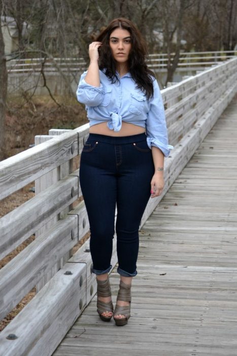 Chica curvi usando un crop top en color mezclilla