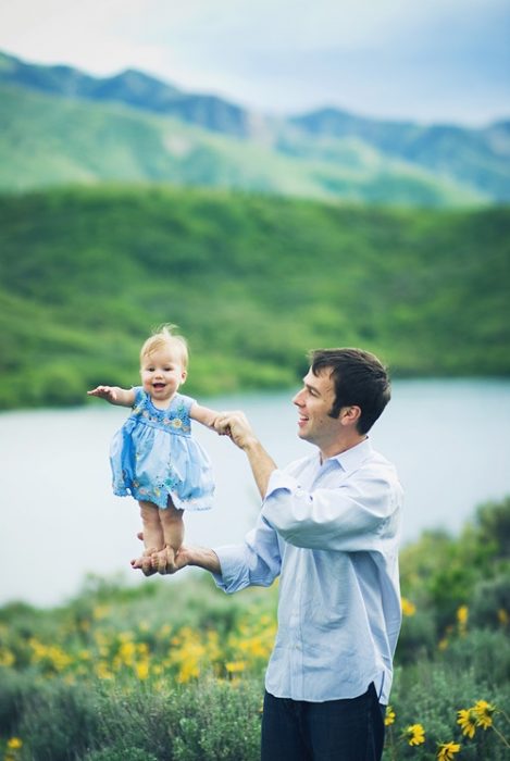 Padre sujetando a su hija de las piernas 