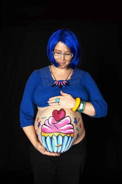 Pancita de una chica embarazada pintada con un cupcake
