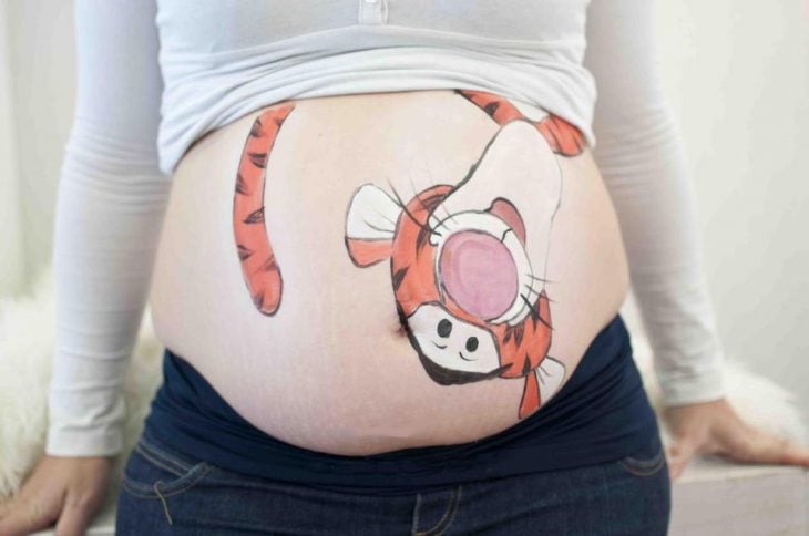 Pancita de una chica embarazada pintada con tigger 