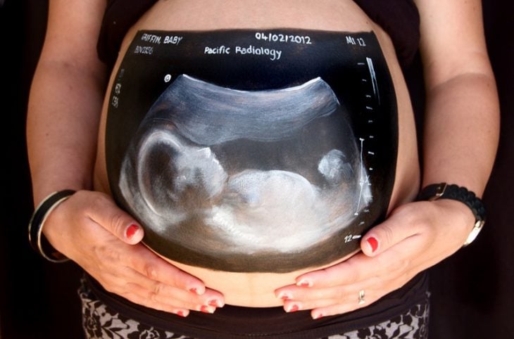 Pancita de una chica embarazada pintada con una ecografía