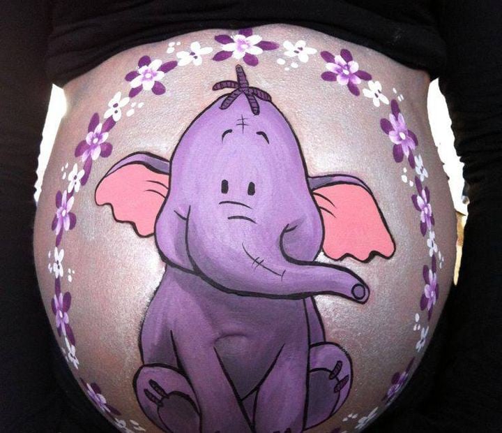 Pancita de una chica embarazada pintada con un elefante morado 