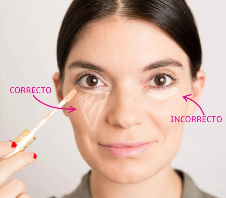 mujer aplicandose corrector para las ojeras 