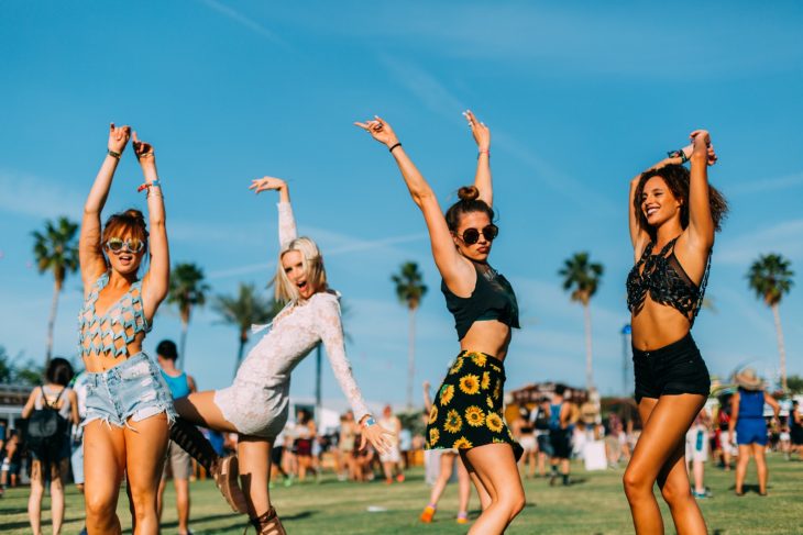 Chicas en un festival levantando los brazos 