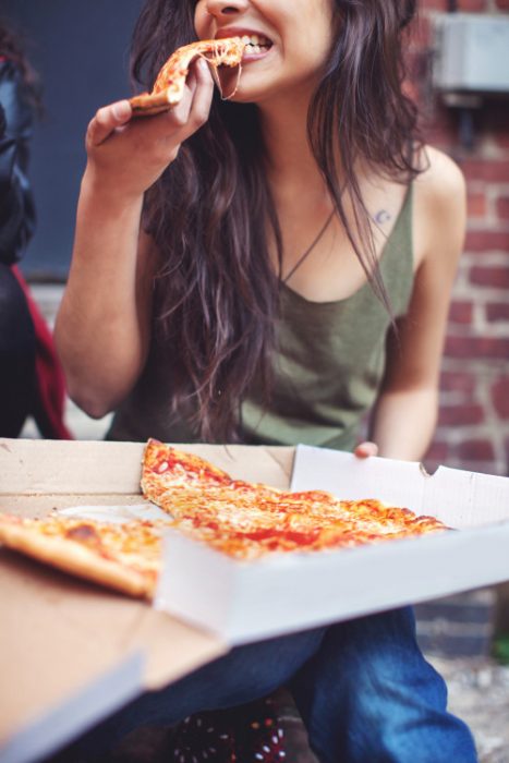 chica comiendo pizza