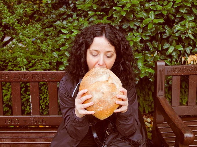 chica comiendo un pan muy grande
