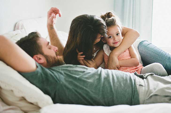 familia jugando en cama