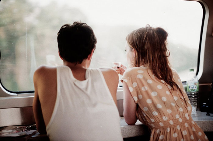 hombre y mujer platicando en una ventana 