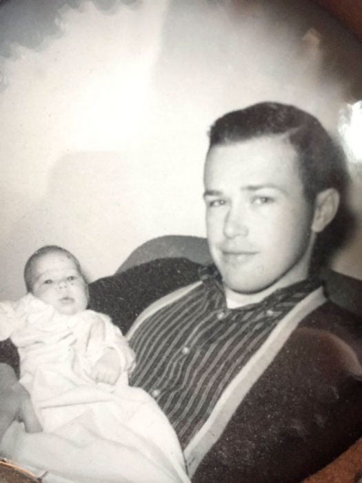 Abuelo guapo cargando a un bebé en una fotografía antigua 