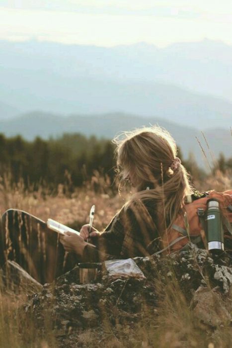 Chica escribiendo en un prado 