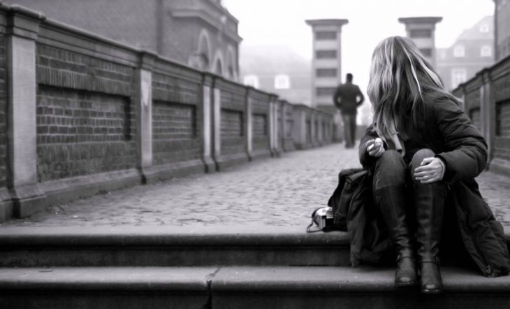 Chica viendo como un chico se aleja por un puente