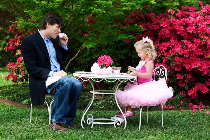 Padre e hija tomando el té mientras están en el jardín 