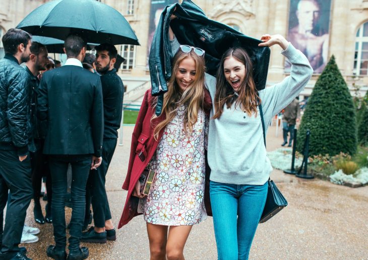 Amigas sonriendo bajo la lluvia 