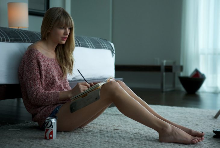 chica escribiendo con coca de dieta a un lado