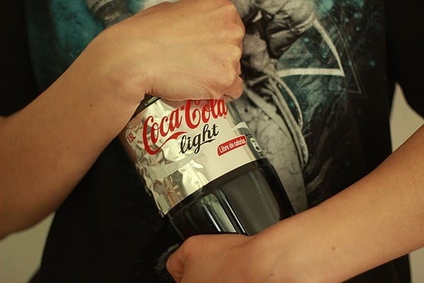 mujer abrazando una botella de coca cola light