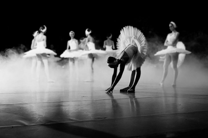 Bailarina de ballet agachada en el escenario 