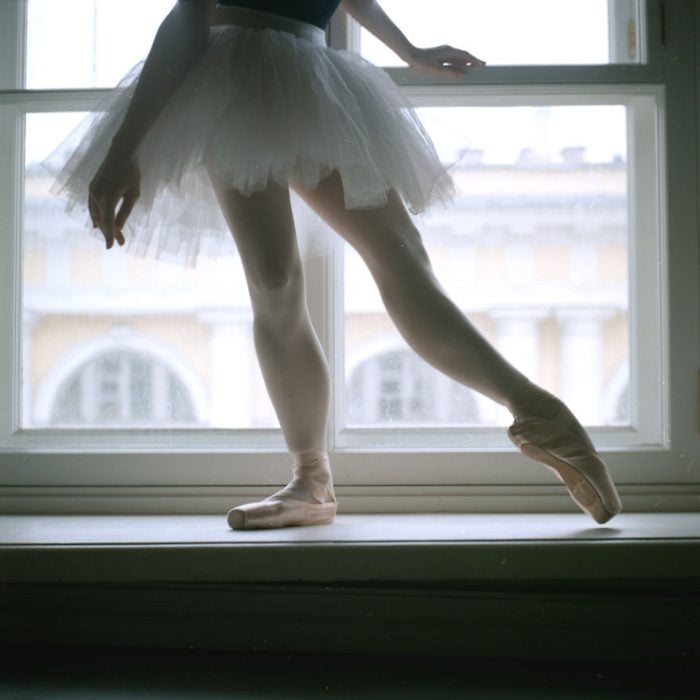 Bailarina de ballet parada sobre una ventana 