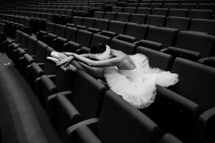 Bailarina de ballet descansando en una butaca del teatro 