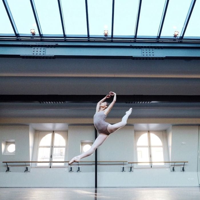 Bailarina de ballet dando saltos en un estudio 