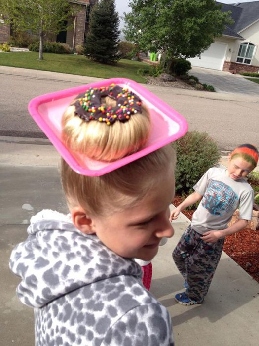 Niña con el cabello en un moño simulando una dona 