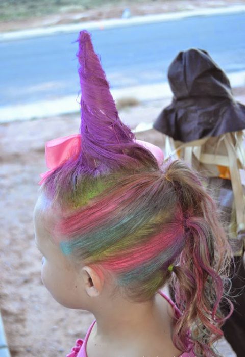 Niña con el cabello en forma de un cuerno de unicornio 