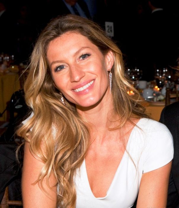 mujer rubia con camisa blanca sonriendo 