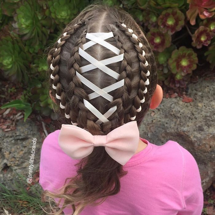 Niña con el cabello trenzado con listones y moños