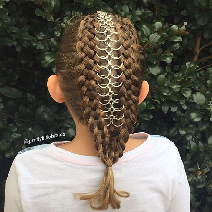 Niña con el cabello trenzado con algunas argollas