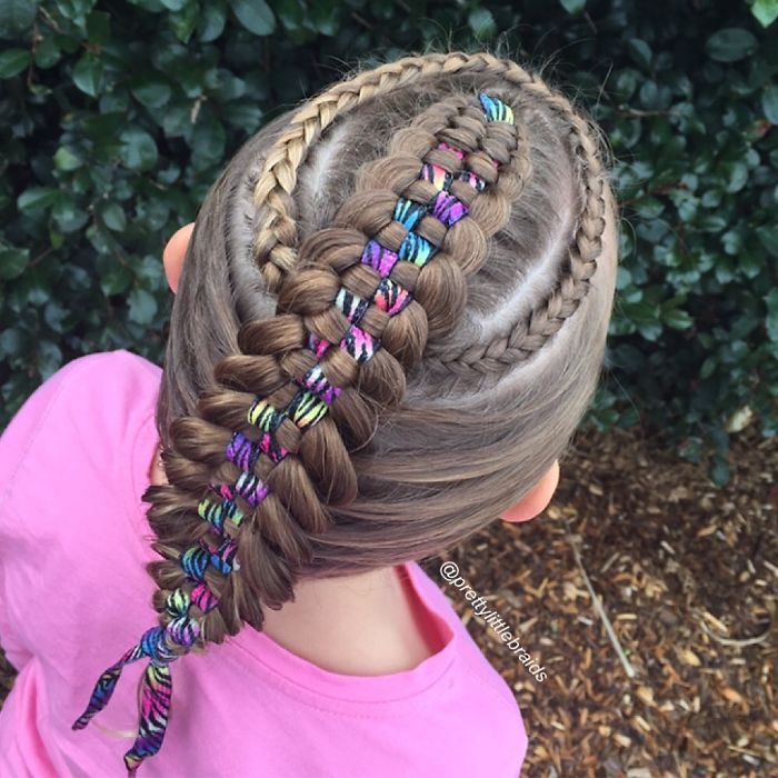 Niña con el cabello trenzado con listón en medio