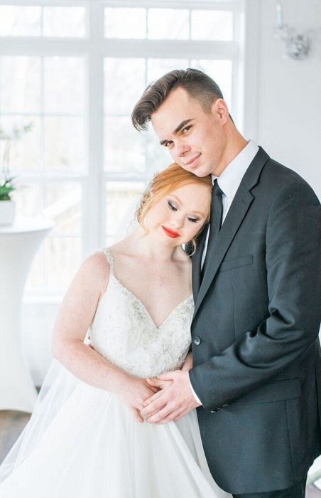 Modelo con síndrome de Down Madeline Stuart posando para una fotografía junto a un chico ambos vestidos de novios 