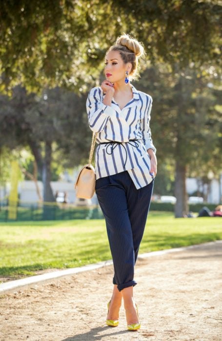Outfit de oficina. Chica usando una blusa a rayas y un pantalón azul 