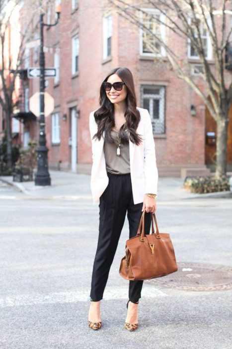 Outfit de oficina. Chica usando un pantalón negro, una blusa color café y un saco color marfil 