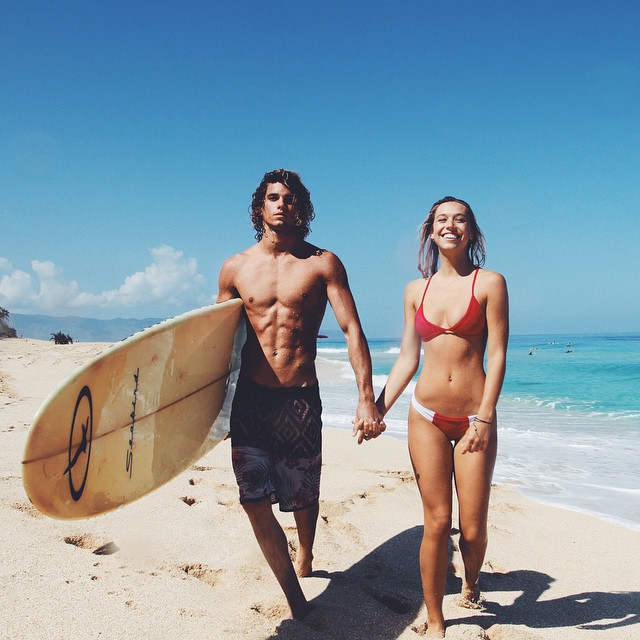 Jay Alvarrez y Alexis Ren Pareja de novios que viajan al rededor del mundo en la playa surfeando 