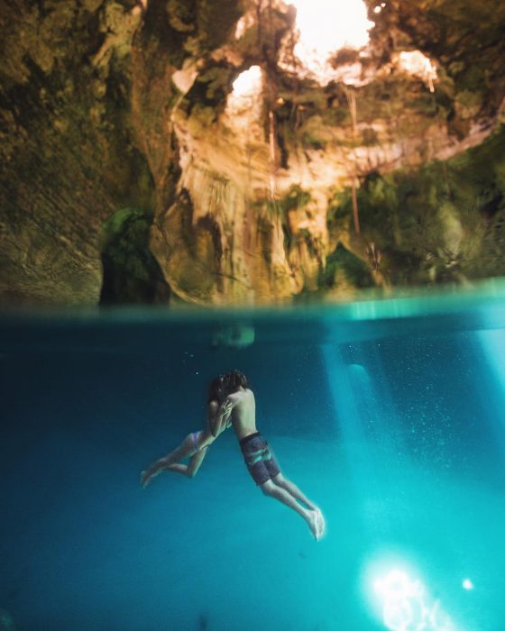 Jay Alvarrez y Alexis Ren Pareja de novios que viajan al rededor del mundo besándose en un ojo de agua