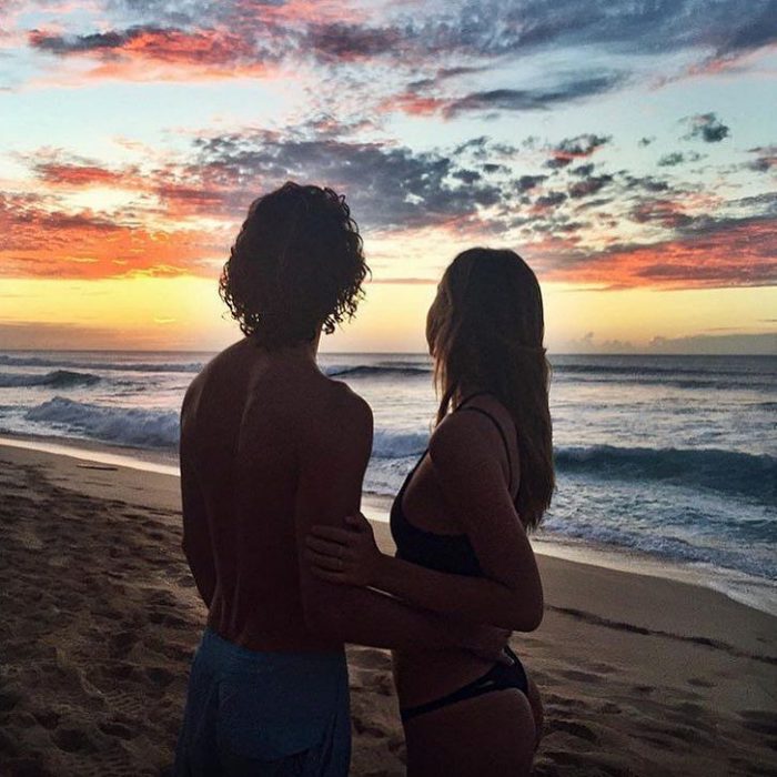 Jay Alvarrez y Alexis Ren Pareja de novios que viajan al rededor del mundo viendo una puesta de sol