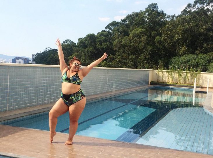 Chica Plus Size en bikini tomando el sol en la piscina