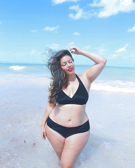 Chica Plus Size en bikini tomando el sol en la playa