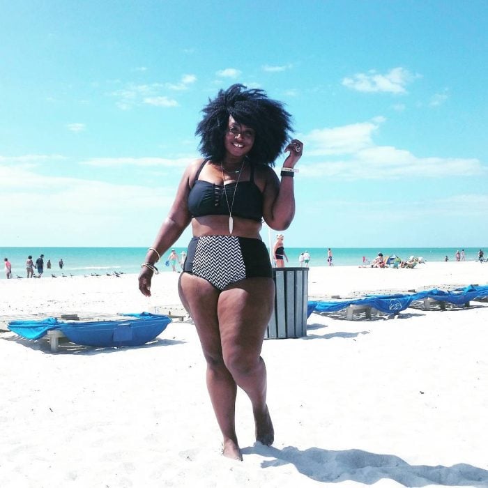 Chica Plus Size en bikini tomando el sol en la playa