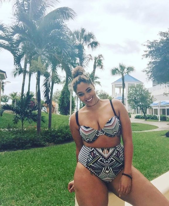 Chica Plus Size en bikini sonriendo en un jardín