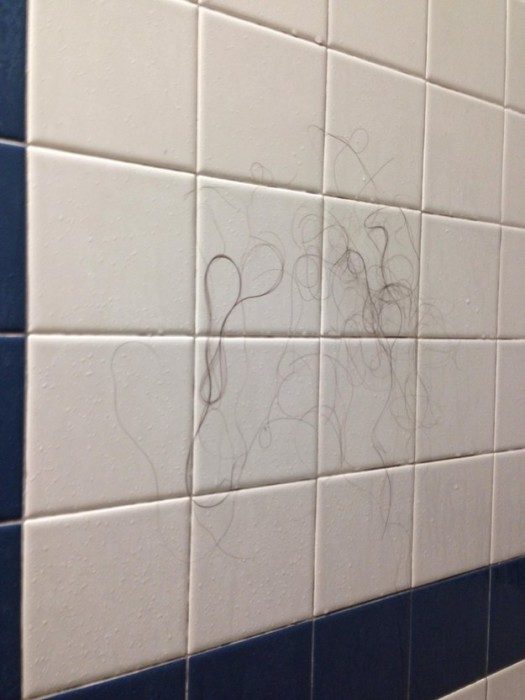 Azulejos del baño llenos de cabello de una chica 