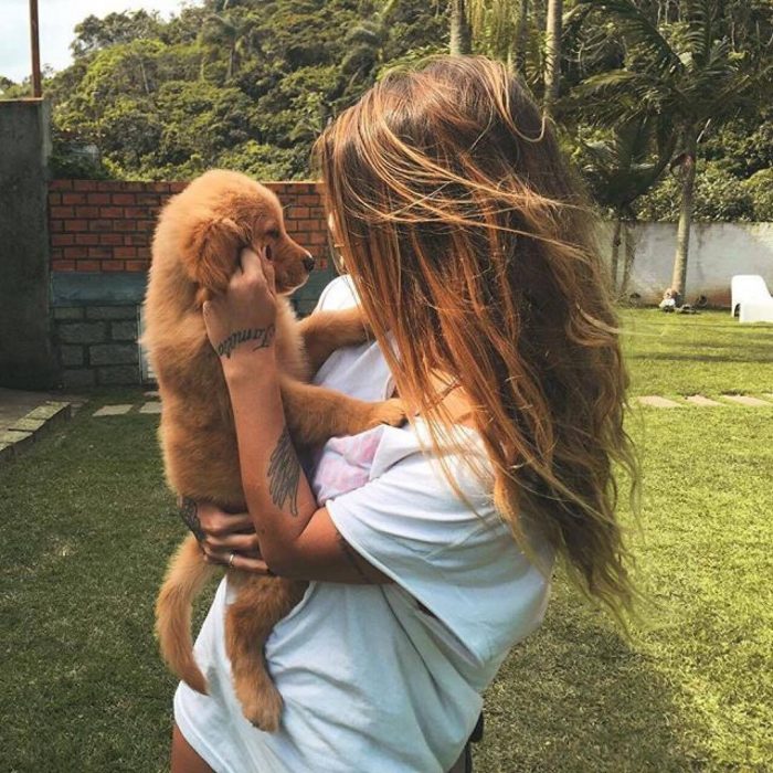 Chica cargando a un cachorro golden 