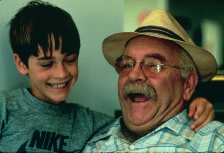 niño y abuelo con lentes y sombrero riendo 