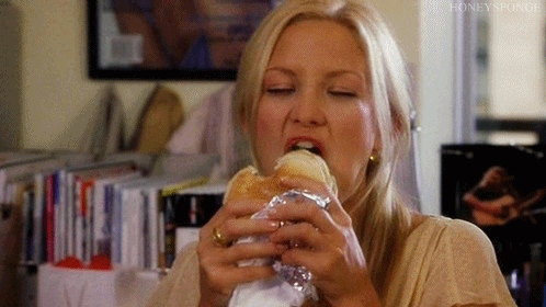 mujer rubia comiendo subway hace cara graciosa 