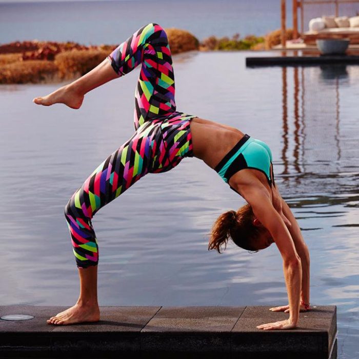 mujer haciendo yoga y pose en muelle lago 