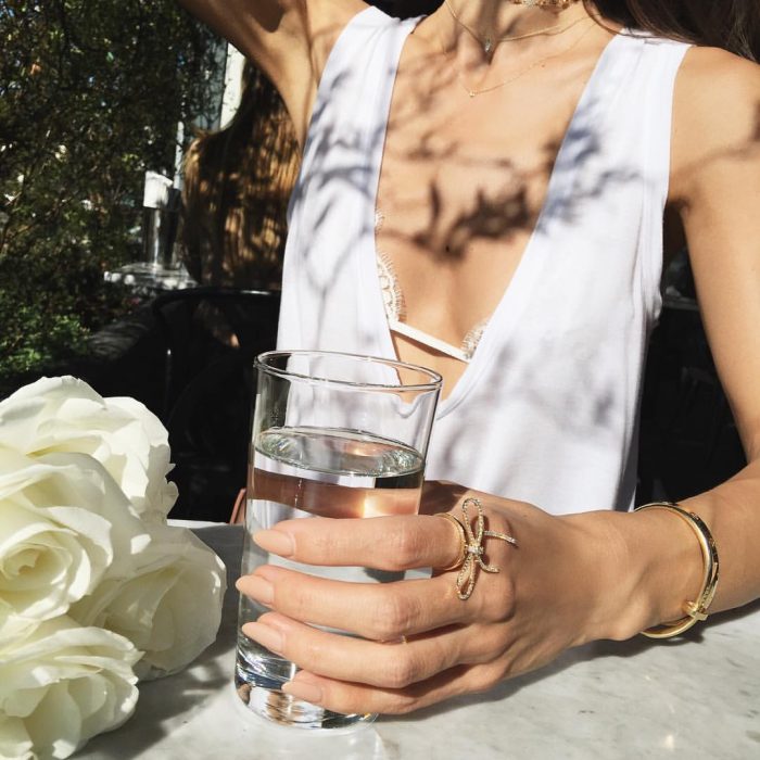 mujer sentada con un vaso de agua en la mano 